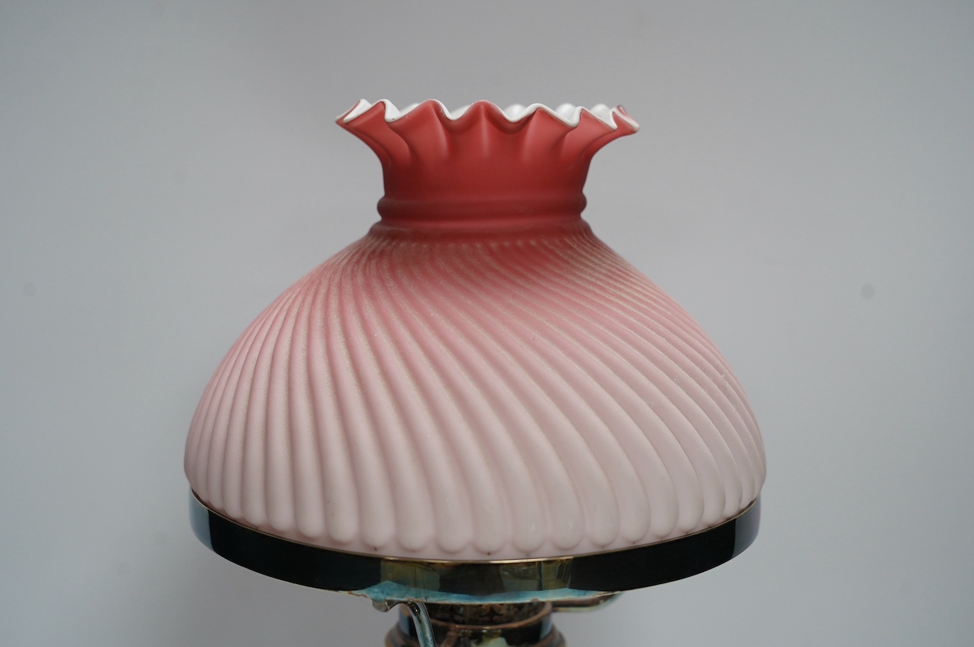 A silver plated table lamp, with a pink satin glass wrythen fluted shade, 41cm high. Condition - shade cracked, lamp untested